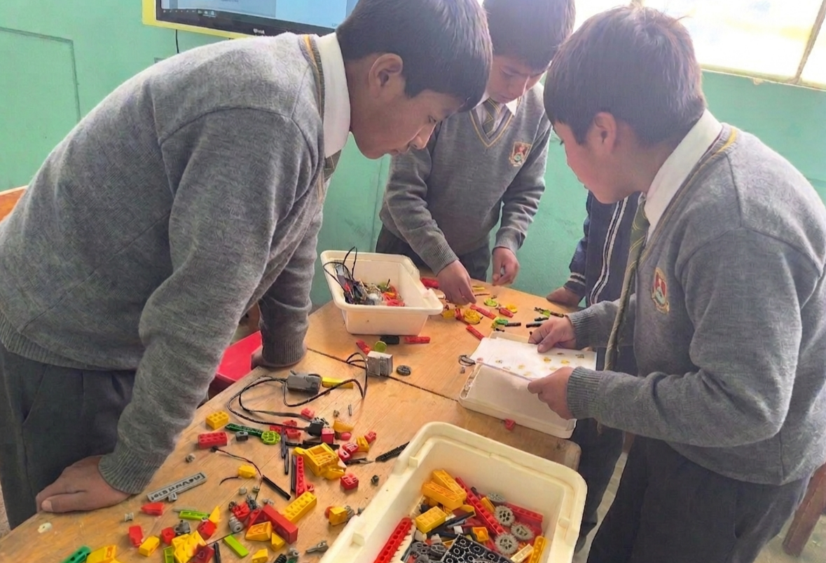 Estudiantes construyendo robots con LEGO y electrónica en colegio peruano